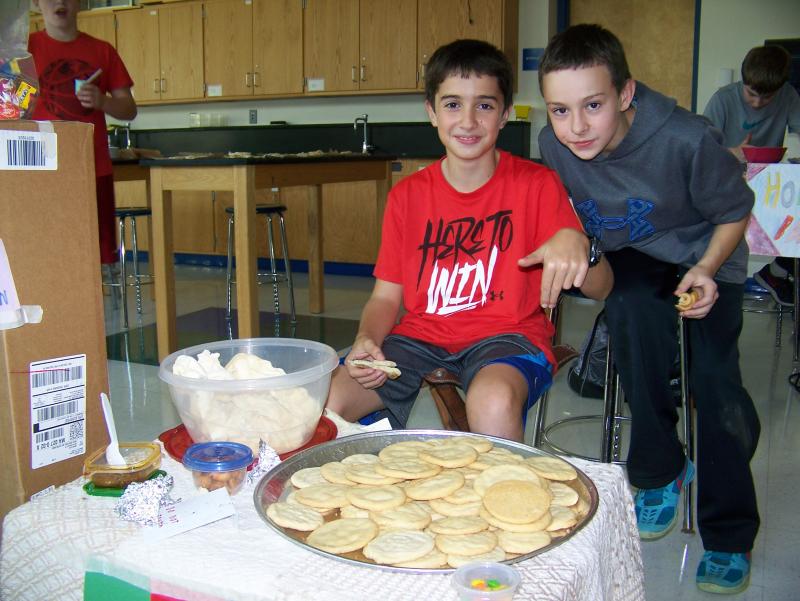Thomas Bothelho (left) and RJ Vickery sell cookies at the market. Bothelho said they settled on that as a good business decision because "everybody likes sugar". BY MATTHEW BERNAT